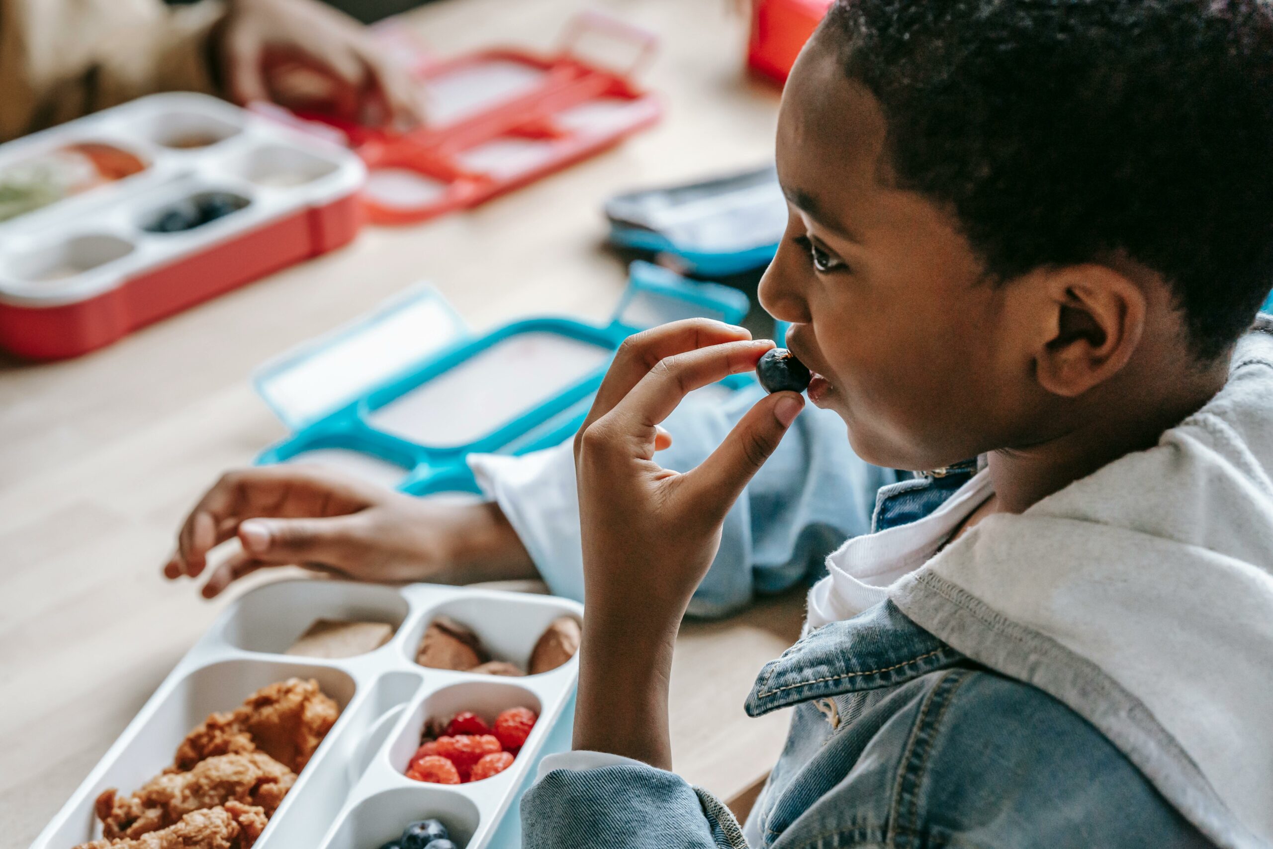 Enfant qui a des troubles de l'oralité qui mange un fruit